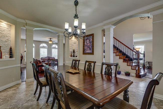 Dining room with decorative columns, plenty of natural light, crown molding, and arched walkways | Image 20