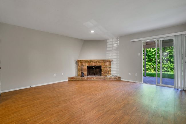 Unfurnished living room with finished floors, recessed lighting, and a fireplace | Image 6