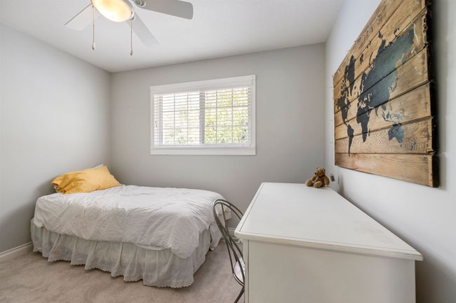 Bedroom with light carpet and a ceiling fan | Image 17