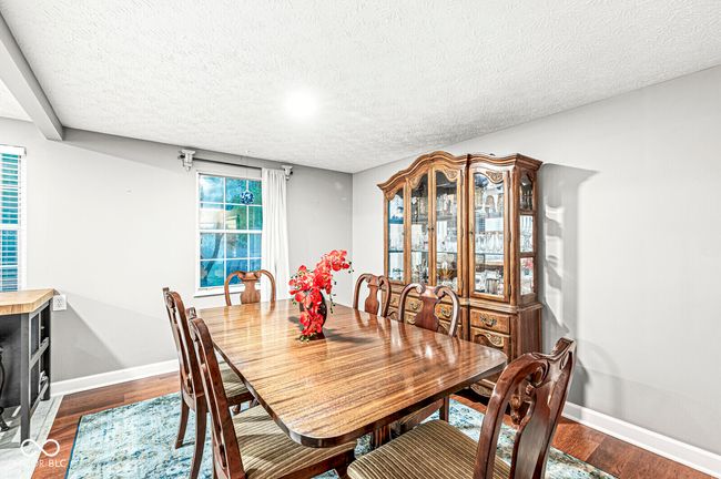 dining room with a textured ceiling and dark wood-style flooring | Image 8