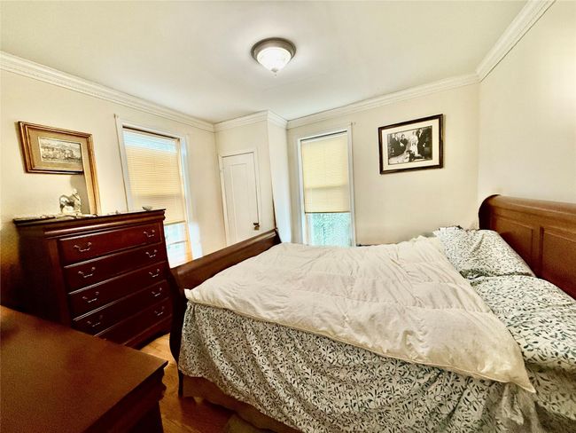Bedroom with ornamental molding and wood finished floors | Image 10