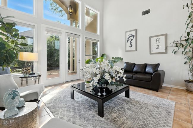 Tiled living room with a high ceiling and baseboards | Image 8