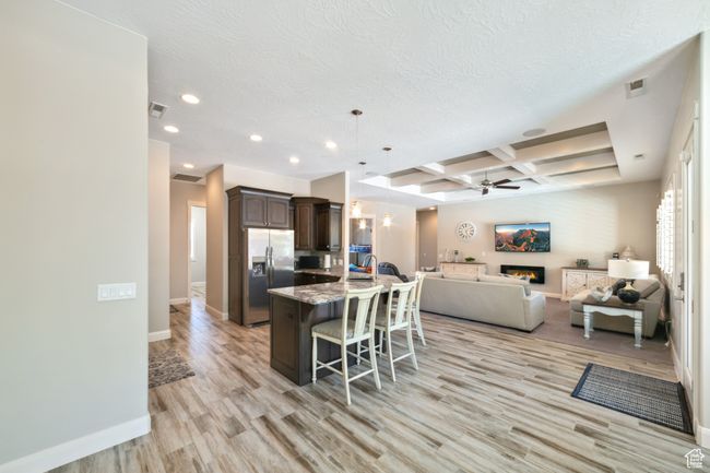 Kitchen with recessed lighting, coffered ceiling, a ceiling fan, stainless steel refrigerator with ice dispenser, and open floor plan | Image 11