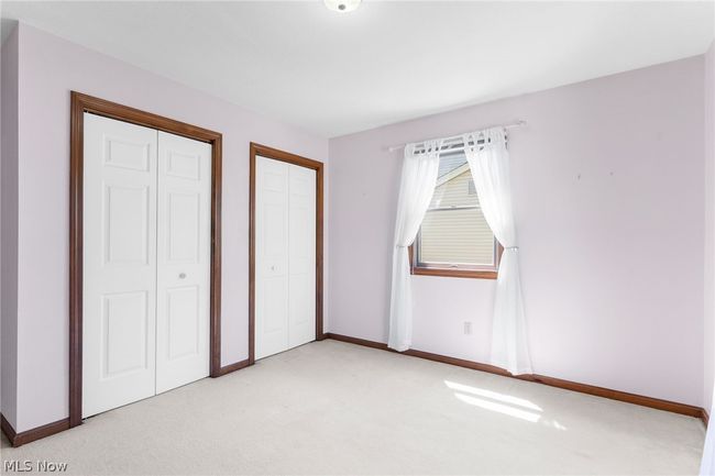 Unfurnished bedroom with light colored carpet and two closets | Image 21