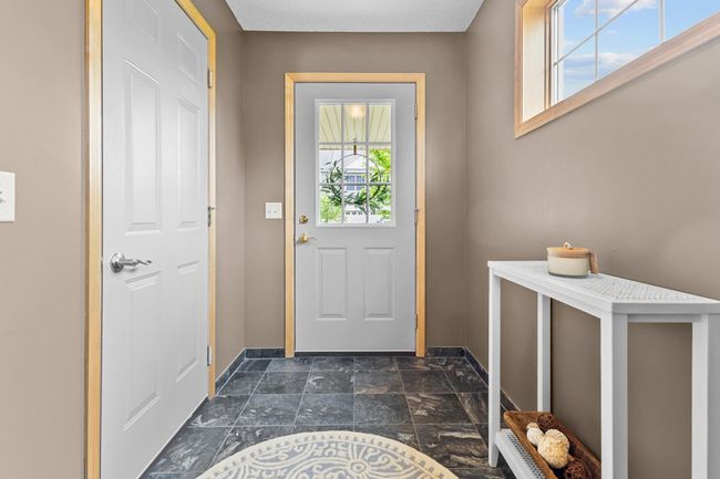 Tiled entryway is light and bright with side windows. Also offers a great coat closet and garage entrance. | Image 12