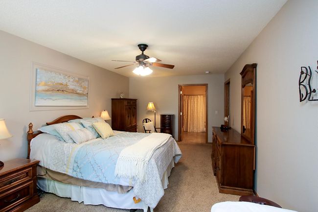 The primary bedroom features a walk-in closet and a private ensuite bathroom. | Image 7