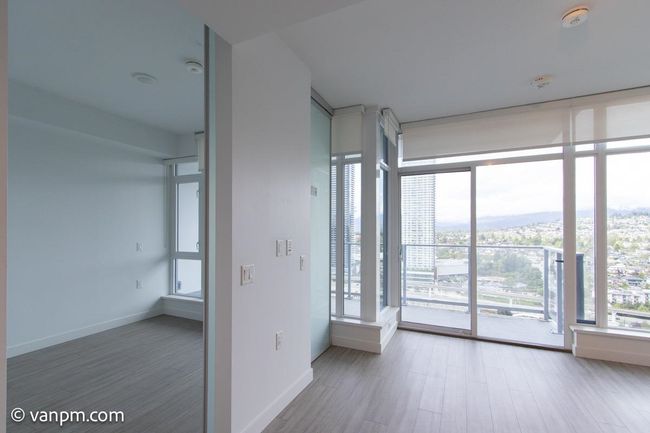 Spare room featuring wood finished floors, a smoke detector, expansive windows, and baseboards | Image 4