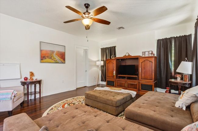 Living room featuring wood finished floors, baseboards, a ceiling fan, and visible vents | Image 19