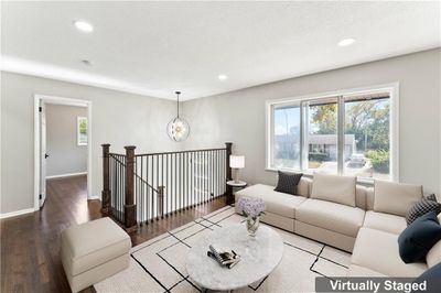 Living room with a notable chandelier, hardwood / wood-style flooring, and a textured ceiling | Image 3