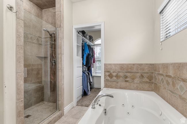 Full bathroom with a tub with jets, a stall shower, tile patterned floors, and a spacious closet | Image 10