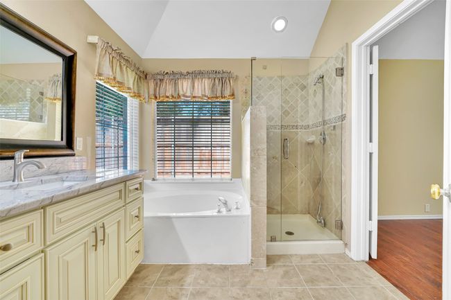 Bathroom featuring lofted ceiling, vanity, shower with separate bathtub, and tile floors | Image 34