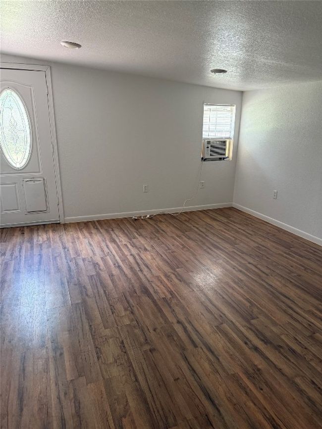 Foyer entrance featuring dark wood-style flooring, cooling unit, and a textured ceiling | Image 8