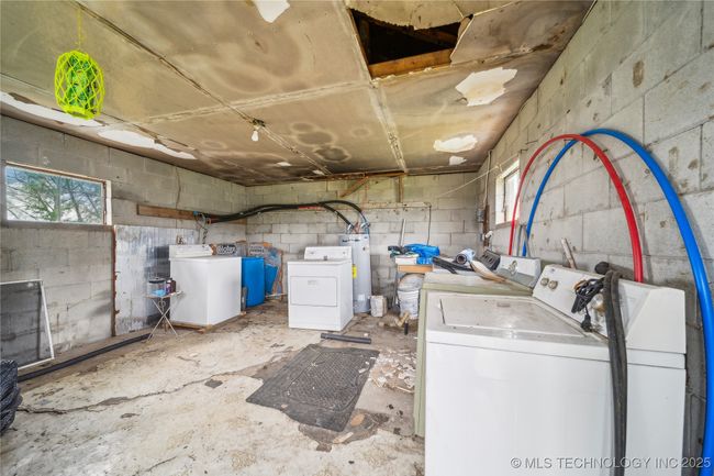 Washroom with independent washer and dryer, concrete block wall, and electric water heater | Image 32