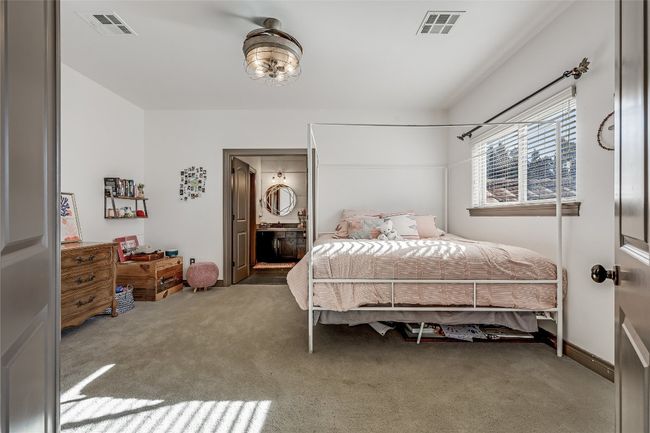 Carpeted bedroom featuring visible vents and connected bathroom | Image 22
