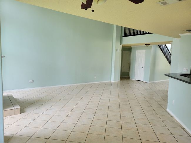 Empty room with ceiling fan, stairway, and light tile patterned flooring | Image 10