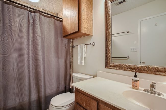 Full bathroom featuring vanity, a shower with shower curtain, and a textured ceiling | Image 14