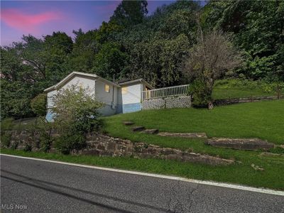 Property exterior at dusk with a lawn | Image 1