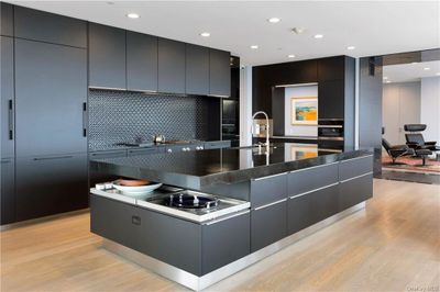 Kitchen with light hardwood / wood-style flooring, sink, stainless steel appliances, and decorative backsplash | Image 2