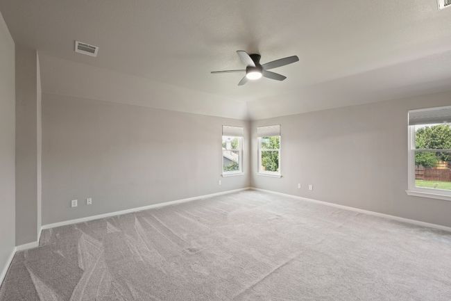 Empty room with a ceiling fan, carpet floors, healthy amount of natural light, and baseboards | Image 21