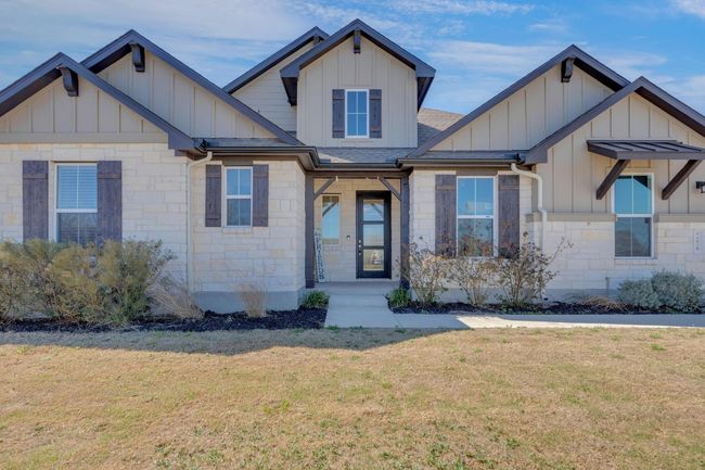 Craftsman house featuring stone siding, board and batten siding, a front yard, and roof with shingles | Image 40