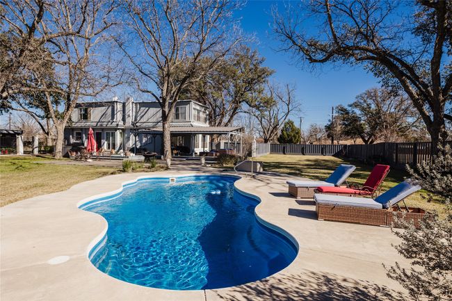 View of swimming pool featuring a patio area and a lawn | Image 37