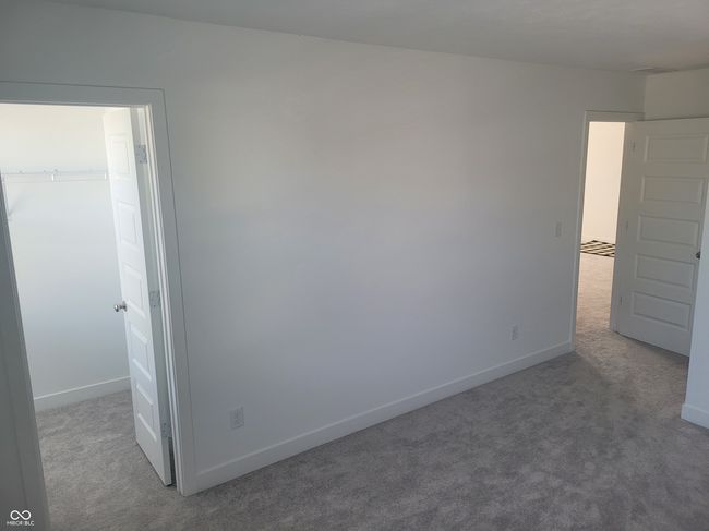 unfurnished bedroom featuring carpet and a walk in closet | Image 11