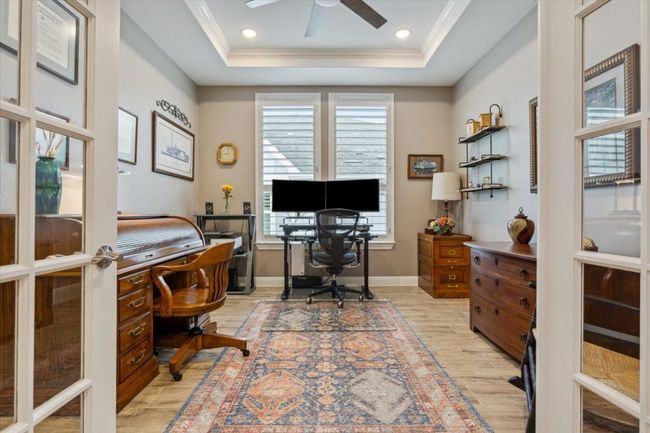 Office space/Flex Room featuring light wood look tile flooring, ceiling fan, a framed dropped soffit with crown molding, and recessed lighting | Image 6