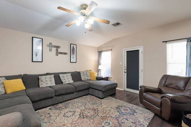 Living room featuring lofted ceiling, dark wood-style floors, and a ceiling fan | Image 9