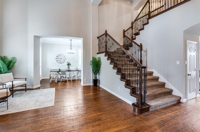 Foyer with a high ceiling, stairway, wood finished floors, arched walkways, and living/dining to the left. Under the stairs there is lots more storage too! | Image 35