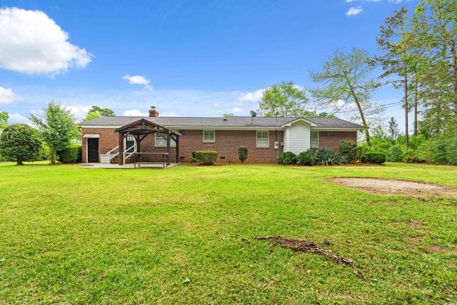 Rear view of property featuring brick siding, a gazebo, and a yard | Image 28