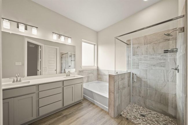 Luxurious ensuite bathroom with double sinks, soaking tub, and a large glass-enclosed shower. | Image 19