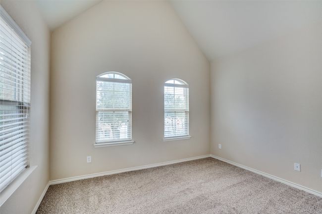Carpeted second bedroom with high vaulted ceiling and baseboards | Image 20