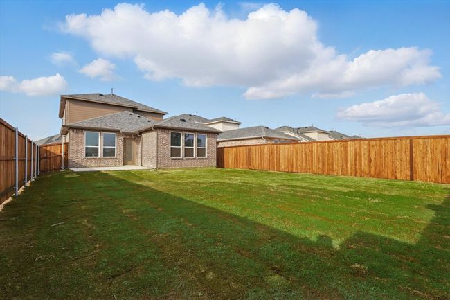 Rear view of house with a fenced backyard, a lawn, brick siding, and roof with shingles | Image 23