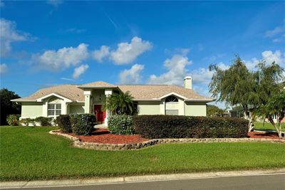 Welcome to this stunning 3-bedroom, 2.5-bath single-story home, perfectly situated on a spacious lot that boasts meticulously maintained landscaping and undeniable curb appeal. This residence impresses with eye-catching architectural details, such as arched windows, a charming, covered entry supported by classic columns, and a striking red front door that adds a vibrant touch of color. By day, the property shines with clean lines and manicured surroundings, while at night, vibrant accent lighting highlights the home’s features, creating a warm and welcoming ambiance. The expansive lawn offers ample space for outdoor activities, and the privacy and scenic views making this home a peaceful retreat within an established and tranquil community.Inside, the spacious master bedroom provides a luxurious escape with double doors opening to a bright, airy room featuring high ceilings and abundant natural light. Sliding glass doors offer a view of the pool, connecting the indoor space seamlessly with the outdoor oasis | Image 1