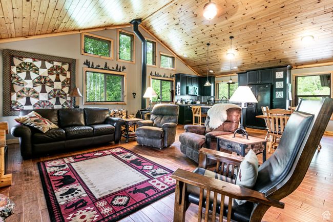 Living area with wooden ceiling, plenty of natural light, high vaulted ceiling, and light wood finished floors | Image 8