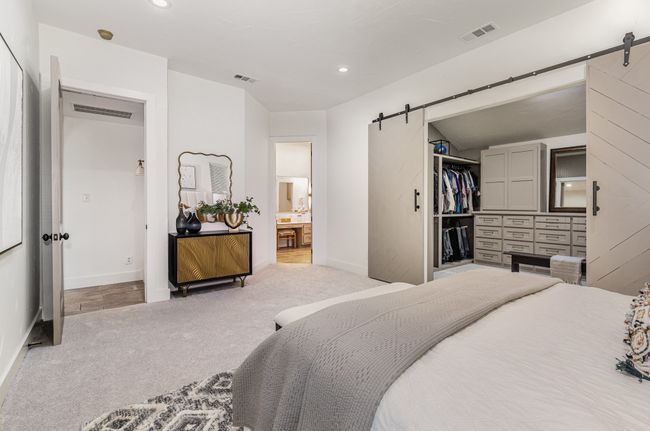 Carpeted bedroom featuring a barn door, recessed lighting, ensuite bathroom, a closet, and a spacious closet | Image 18