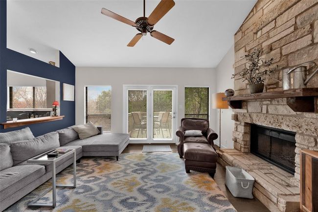 Living area featuring vaulted ceiling, ceiling fan, and a fireplace | Image 4