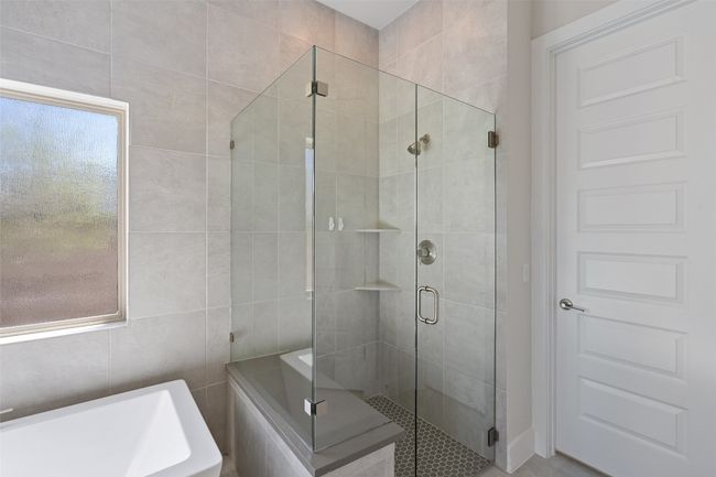 Full bathroom featuring a bath, a shower stall, and tile walls | Image 23