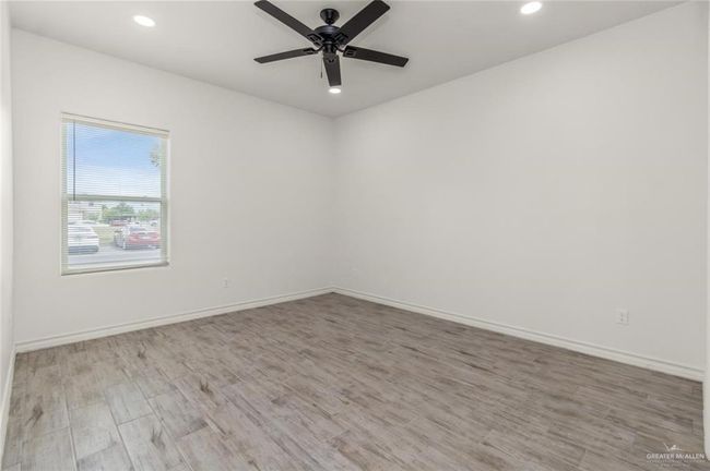 Unfurnished room with wood finished floors, ceiling fan, and recessed lighting | Image 6