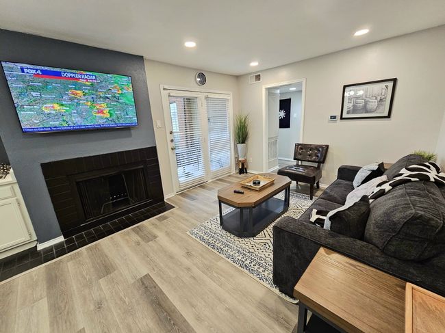 Living area with wood finished floors, recessed lighting, baseboards, and a fireplace with flush hearth | Image 4