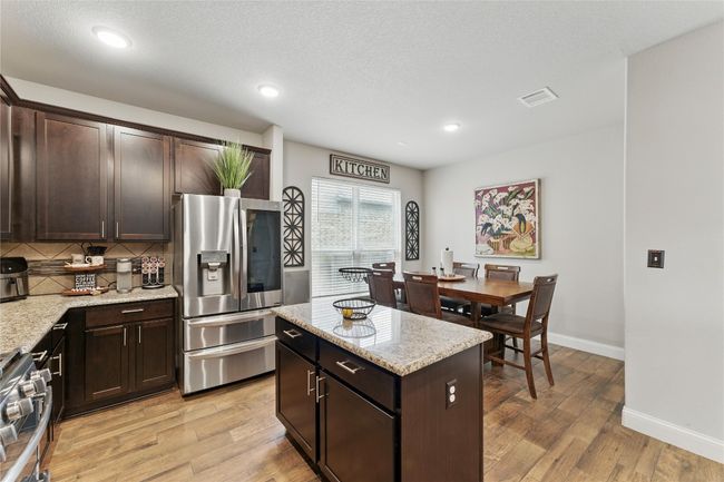 Kitchen featuring stainless steel appliances, light wood finished floors, visible vents, and backsplash | Image 11