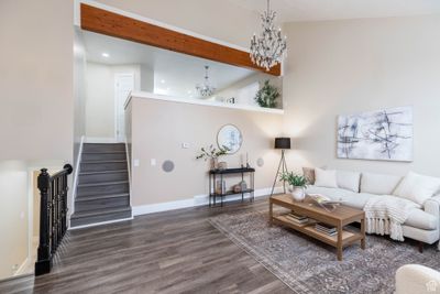 Living room with high vaulted ceiling, a notable chandelier, beamed ceiling, and dark hardwood / wood-style floors | Image 2