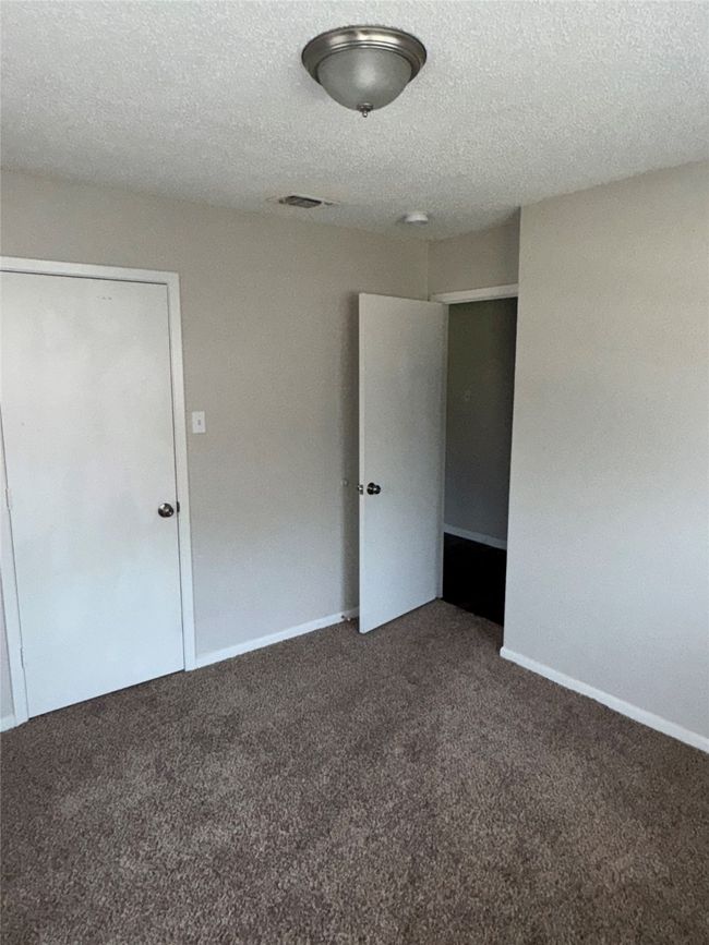 Unfurnished bedroom with carpet flooring, a textured ceiling, and baseboards | Image 11