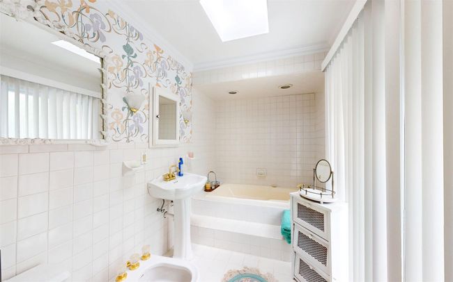 Full bathroom with a bath, a bidet, tile walls, heating unit, and ornamental molding | Image 36