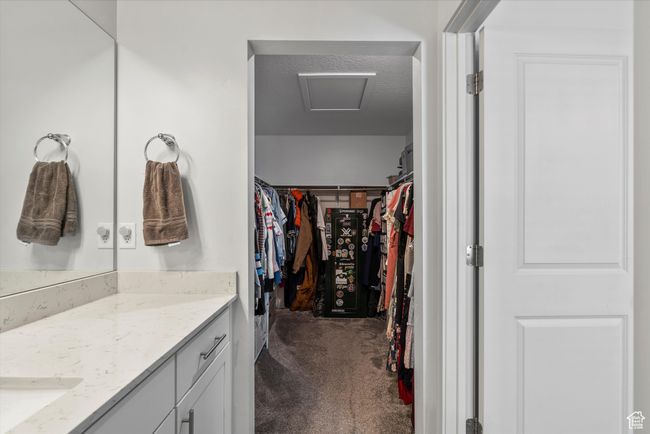 Walk in closet featuring dark carpet and attic access | Image 16