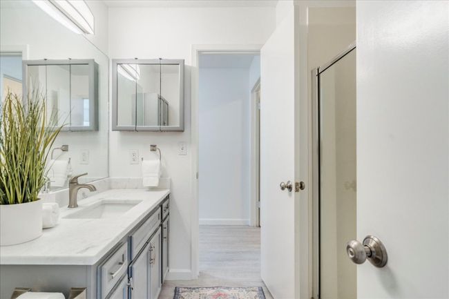 Bathroom featuring vanity, baseboards, wood finished floors, and an enclosed shower | Image 22