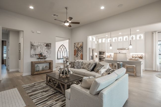 Living area featuring ceiling fan, light wood-style flooring, recessed lighting, baseboards, and a towering ceiling | Image 16