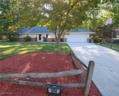 Ranch-style house with a front lawn and a garage | Image 1