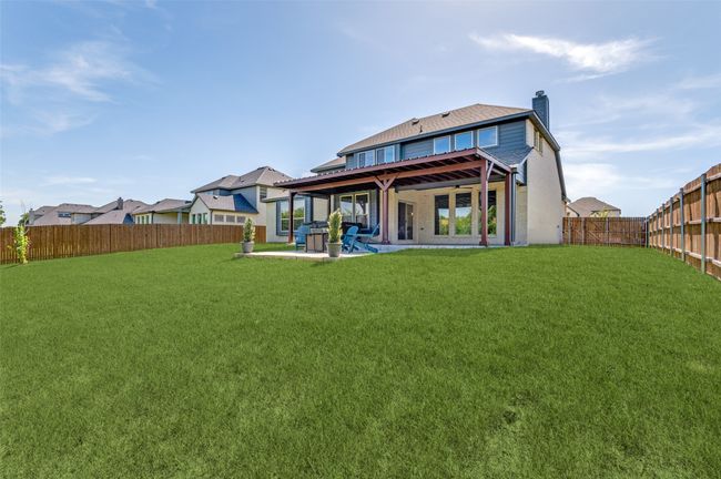 Back of property featuring a chimney, a fenced backyard, and a patio | Image 38