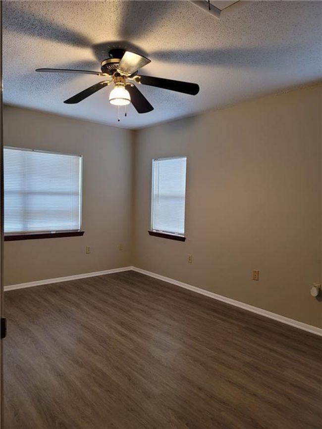 Unfurnished room with dark wood finished floors, healthy amount of natural light, ceiling fan, and a textured ceiling | Image 12